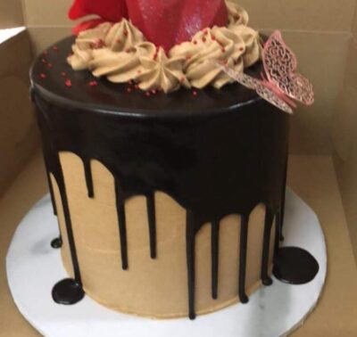 Round chocolate drip cake with red chocolate hearts